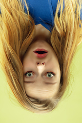 Image showing Inverted portrait of caucasian young woman on yellow studio background