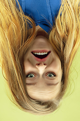 Image showing Inverted portrait of caucasian young woman on yellow studio background