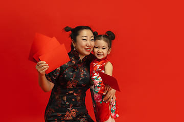 Image showing Happy Chinese New Year. Asian mother and daughter portrait isolated on red background