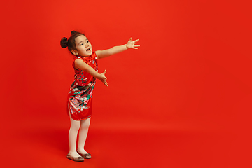 Image showing Happy Chinese New Year. Asian little girl portrait isolated on red background