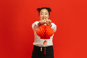 Image showing Happy Chinese New Year. Asian young woman portrait isolated on red background