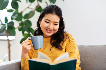 Image showing woman reading book and drinking coffee at home