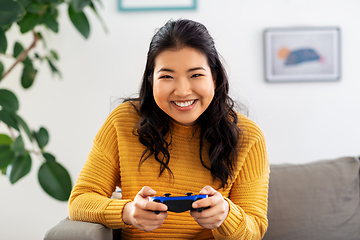 Image showing asian woman with gamepad playing game at home