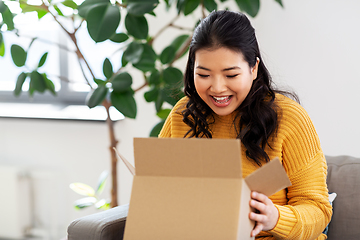 Image showing happy asian young woman with parcel box at home