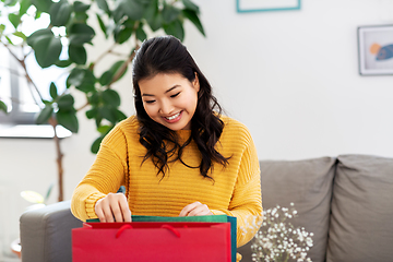 Image showing asian young woman with shopping bag at home