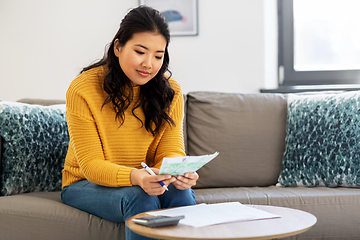 Image showing woman with money, papers and calculator at home