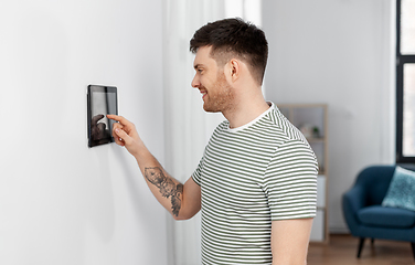 Image showing smiling man using tablet computer at smart home