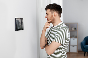 Image showing man looking at tablet computer at smart home