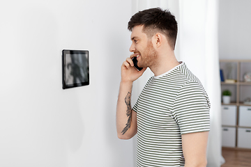 Image showing smiling man using tablet computer at smart home