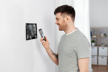 Image showing smiling man using tablet computer at smart home