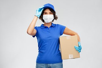 Image showing delivery woman in face mask holding parcel box