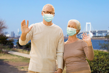 Image showing senior couple in protective medical masks in japan