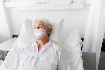 Image showing old woman patient in mask lying in bed at hospital