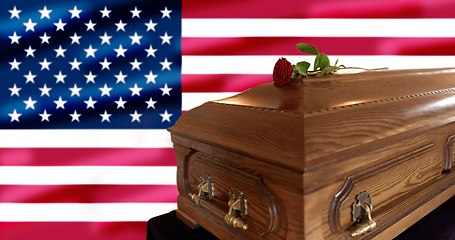 Image showing rose flower on wooden coffin over american flag