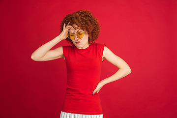 Image showing Caucasian woman\'s portrait isolated over red studio background with copyspace