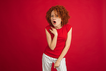 Image showing Caucasian woman\'s portrait isolated over red studio background with copyspace