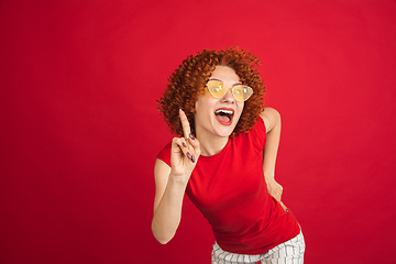 Image showing Caucasian woman\'s portrait isolated over red studio background with copyspace