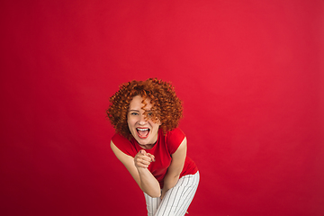 Image showing Caucasian woman\'s portrait isolated over red studio background with copyspace