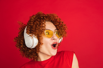 Image showing Caucasian woman\'s portrait isolated over red studio background with copyspace