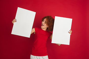 Image showing Caucasian woman\'s portrait isolated over red studio background with copyspace