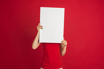 Image showing Caucasian woman\'s portrait isolated over red studio background with copyspace