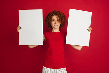 Image showing Caucasian woman\'s portrait isolated over red studio background with copyspace