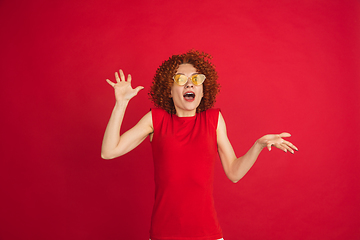 Image showing Caucasian woman\'s portrait isolated over red studio background with copyspace