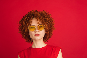 Image showing Caucasian woman\'s portrait isolated over red studio background with copyspace