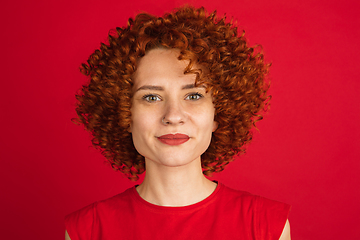 Image showing Caucasian woman\'s portrait isolated over red studio background with copyspace