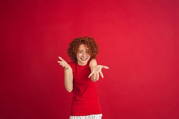 Image showing Caucasian woman\'s portrait isolated over red studio background with copyspace