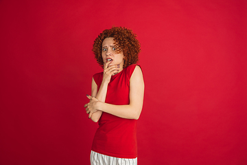 Image showing Caucasian woman\'s portrait isolated over red studio background with copyspace