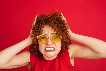 Image showing Caucasian woman\'s portrait isolated over red studio background with copyspace