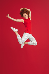 Image showing Caucasian woman\'s portrait isolated over red studio background with copyspace