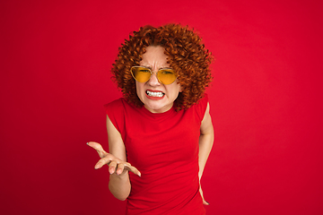 Image showing Caucasian woman\'s portrait isolated over red studio background with copyspace