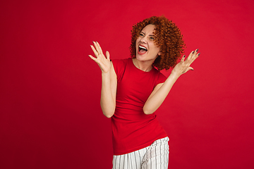 Image showing Caucasian woman\'s portrait isolated over red studio background with copyspace