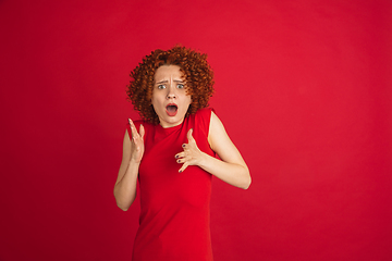 Image showing Caucasian woman\'s portrait isolated over red studio background with copyspace