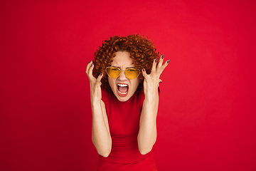 Image showing Caucasian woman\'s portrait isolated over red studio background with copyspace