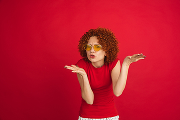 Image showing Caucasian woman\'s portrait isolated over red studio background with copyspace