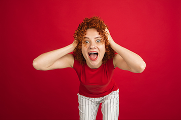 Image showing Caucasian woman\'s portrait isolated over red studio background with copyspace