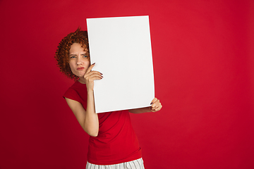 Image showing Caucasian woman\'s portrait isolated over red studio background with copyspace