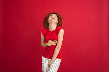 Image showing Caucasian woman\'s portrait isolated over red studio background with copyspace