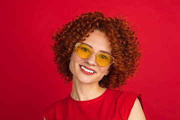 Image showing Caucasian woman\'s portrait isolated over red studio background with copyspace