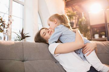 Image showing Family time. Mother and daughter having time together at home, look happy and sincere