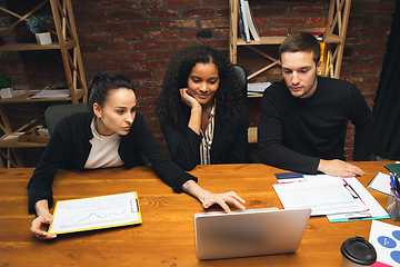 Image showing Colleagues working together in modern office using devices and gadgets during creative meeting