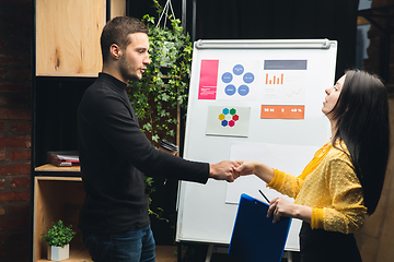 Image showing Colleagues working together in modern office using flipchart during creative meeting