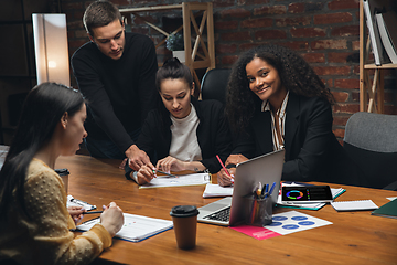 Image showing Colleagues working together in modern office using devices and gadgets during creative meeting