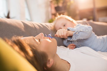 Image showing Family time. Mother and daughter having time together at home, look happy and sincere