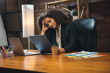 Image showing Young woman working in modern office using devices and gadgets. Making reports, analitycs, routine processing tasks