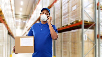 Image showing delivery man in mask with smartphone and parcel