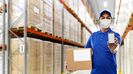 Image showing delivery man in mask with cellphone and parcel box